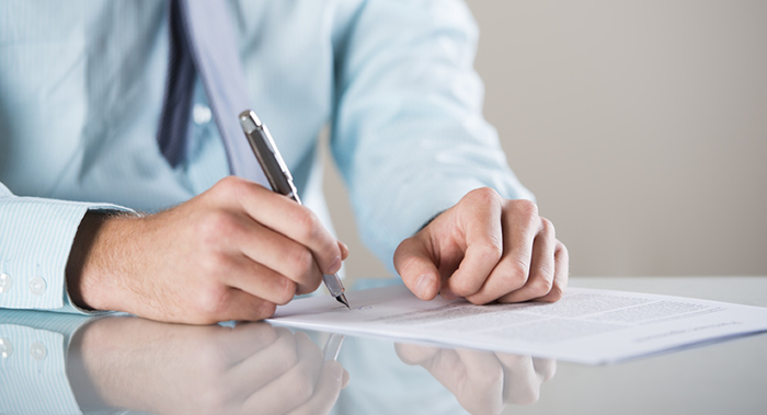 man signing legal papers