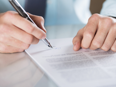 man signing insurance documents