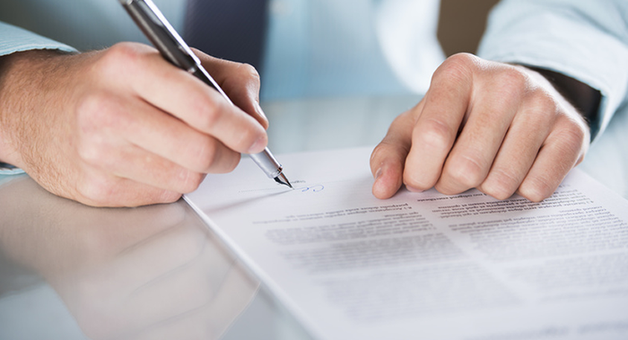 man signing insurance documents